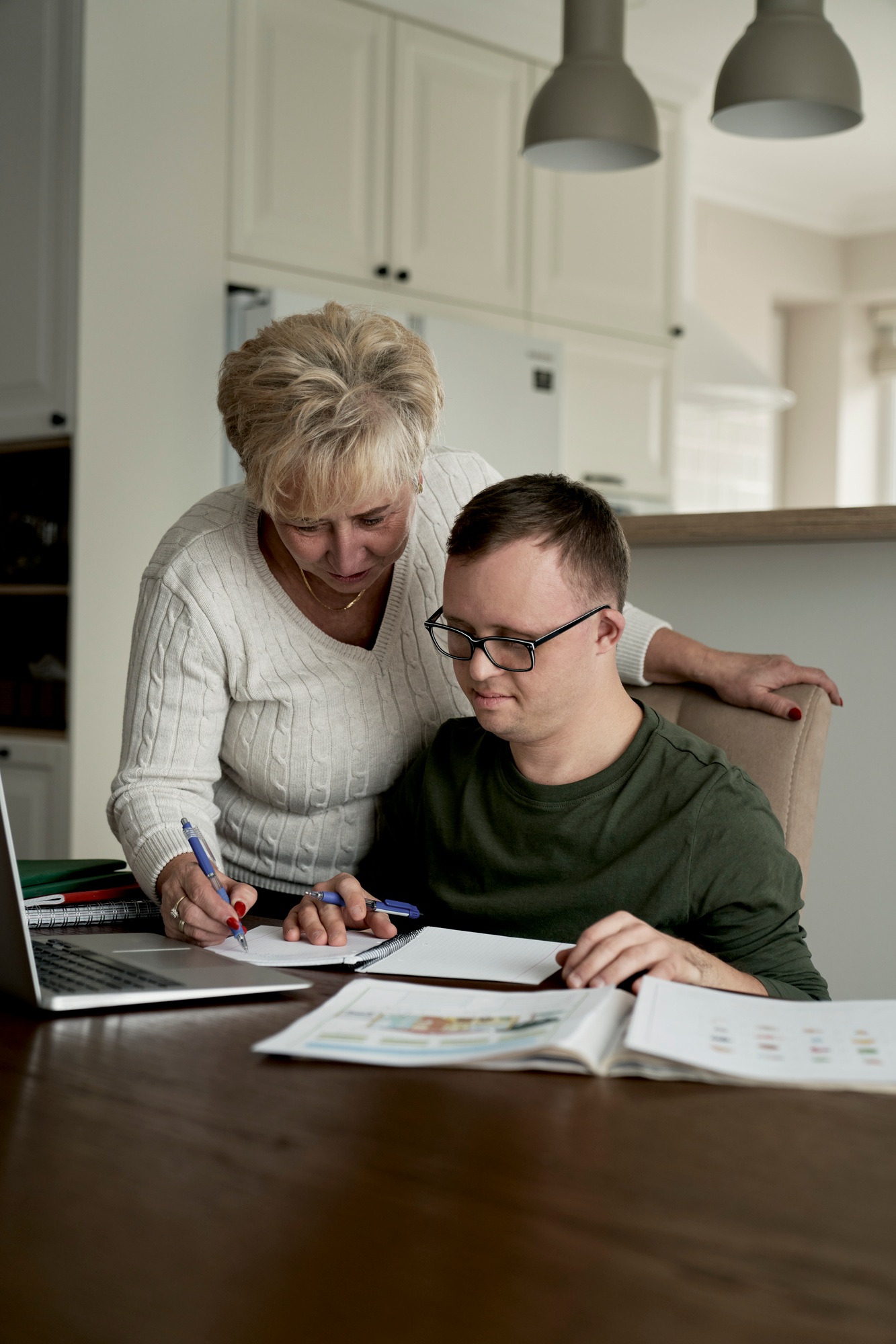 Man with down syndrome learning with his mum at home
